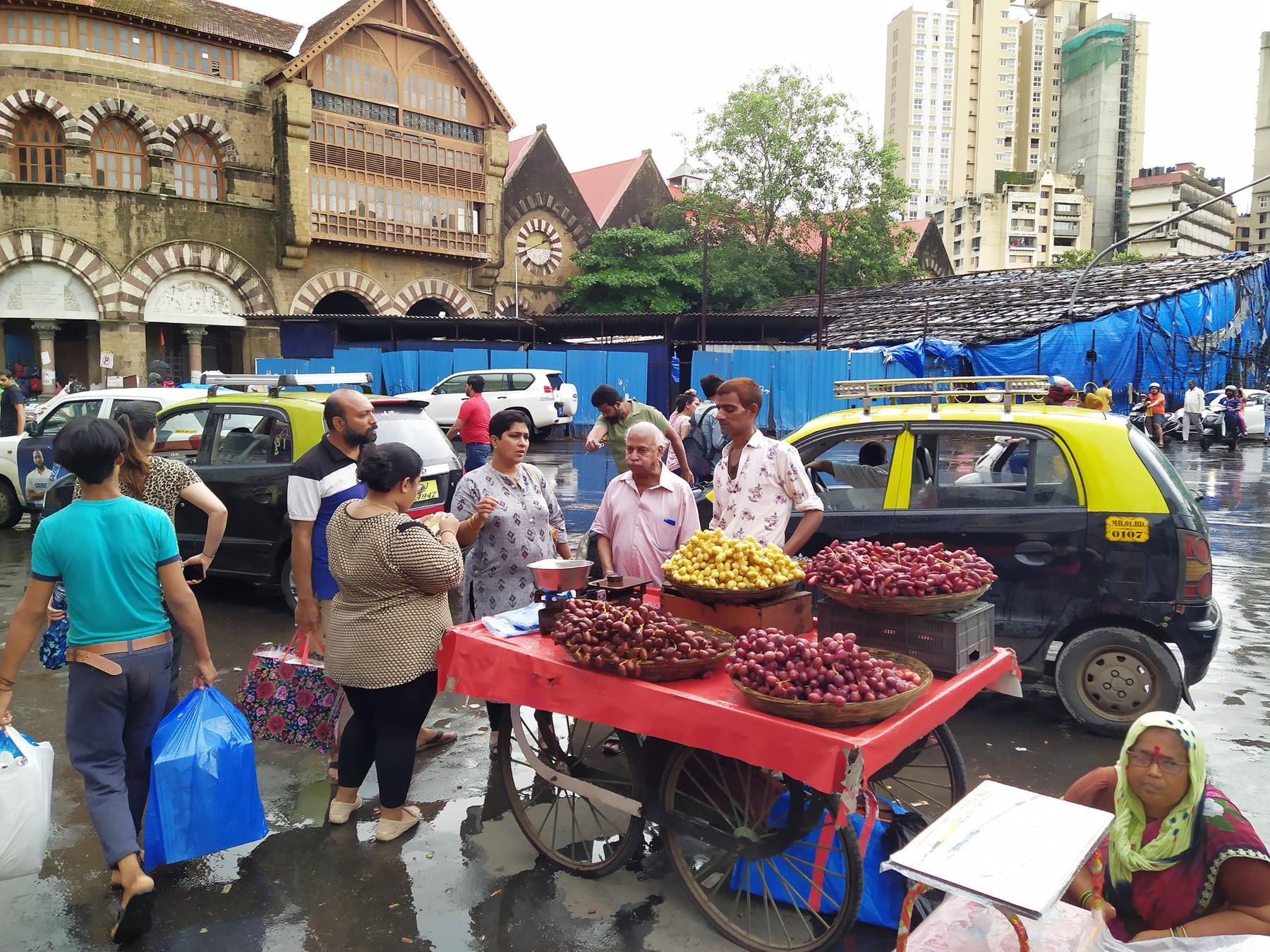 Fruit vendors and customers on a busy food street in Kalbadevi, Mumbai
